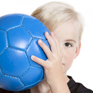 'child holding soccer ball in front of face'